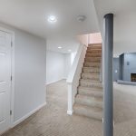 a finished basement with carpeted stairs