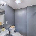 a blue walled bathroom with white vanity and toilet