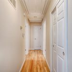 a hallway with a wooden floor and white walls